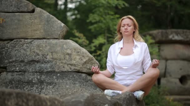 Γυναίκα κάθεται και διαλογίζεσαι πάνω σε πέτρα dolmen — Αρχείο Βίντεο