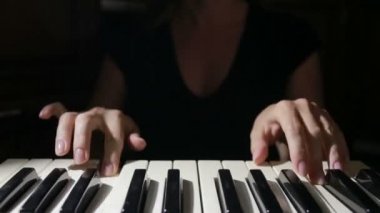 Denetleyici bir MIDI klavye synthesizer oynarken kadın el yakın çekim.