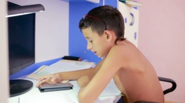 Genç çocuk bir cep telefonu kullanarak ödev yapmak. doğal video