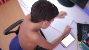 Genç çocuk bir cep telefonu kullanarak ödev yapmak. doğal video