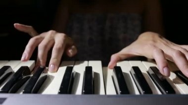 Denetleyici bir MIDI klavye synthesizer oynarken kadın el yakın çekim.