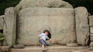Çocuk turist antik yapı keşfetmek. Dolmen. selfie telefon