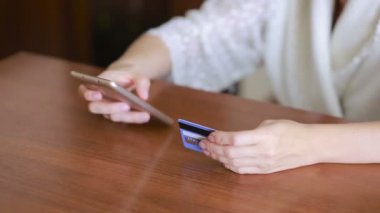 kadın bir smartphone ve banka kartı kullanarak bir satın alma işlemi yaptığı.