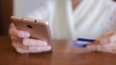 kadın bir smartphone ve banka kartı kullanarak bir satın alma işlemi yaptığı.