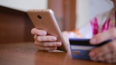kadın bir smartphone ve banka kartı kullanarak bir satın alma işlemi yaptığı.