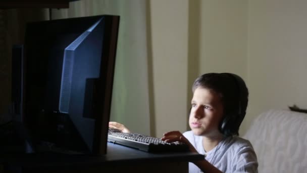 Tiener jongen speelt spelletjes op de computer's nachts. Online spelletjes — Stockvideo