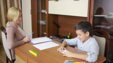 Genç çocuk sessizce oturumu sırasında genç psikolog ile oturuyor..