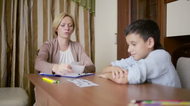 小男孩坐在沉默在会议期间与年轻的心理学家. — 图库视频影像