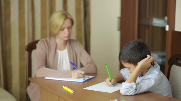 Niño sentado en silencio durante la sesión con el joven psicólogo . — Vídeos de Stock