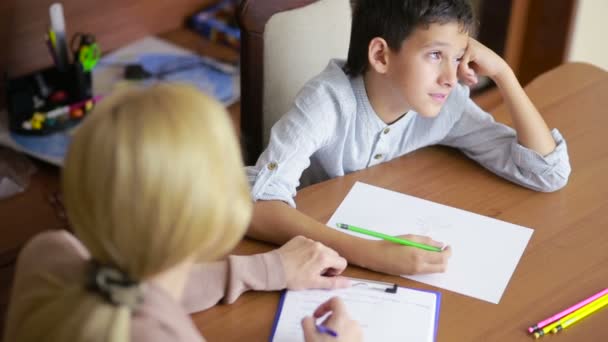 Young boy sitting in silence during session with young psychologist. — Stock Video