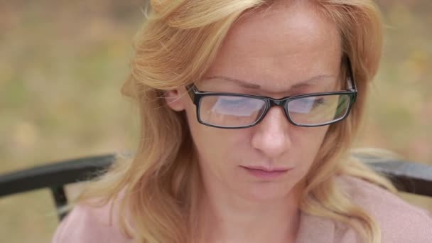 Vrouw met glazen lezen van een boek. Close-up. weerspiegeld in de lenzen van het boek — Stockvideo