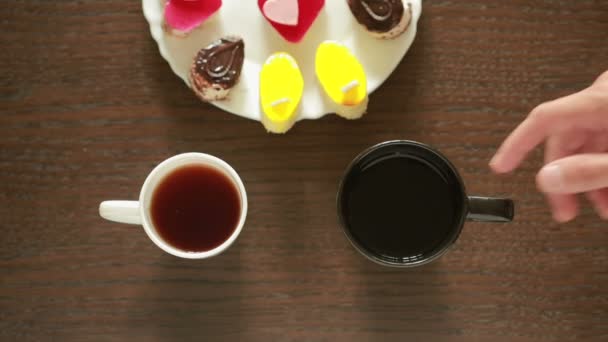 Черный чай в кружках. Обед. столик с напитком и десертом. вид сверху — стоковое видео