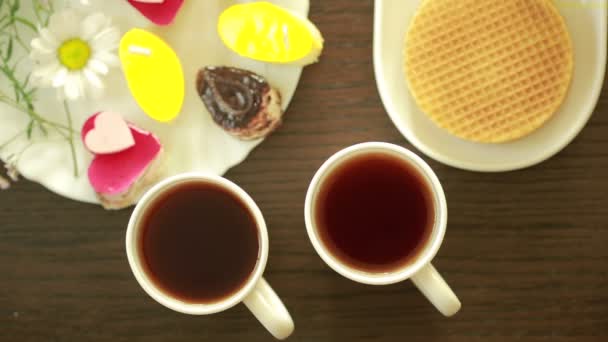 Černý čaj v hrnky. oběd. Tabulka s nápoj a dezert. pohled shora — Stock video