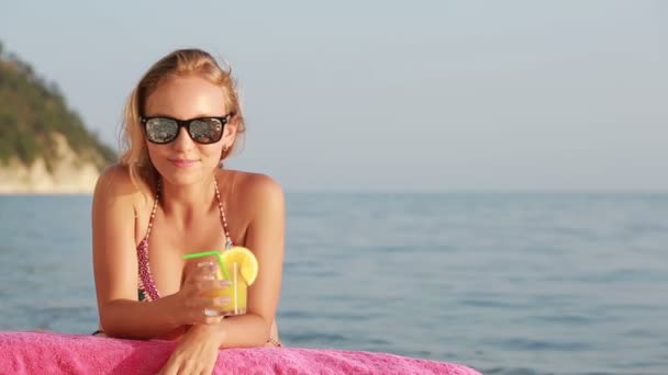 Flicka i bikini dricka juice genom ett sugrör. kvinna vid havet. — Stockvideo