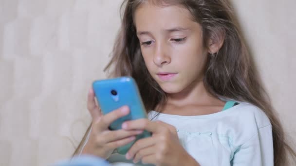 Κορίτσι παιδί με ένα κινητό τηλέφωνο πραγματοποιεί αναζήτηση στο Internet — Αρχείο Βίντεο