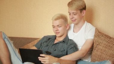 Yatakta tablet kullanan mutlu eşcinsel çift. Eşcinsel çift