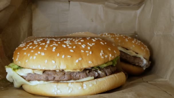 Super detailní záběr. hamburger se sezamovými semínky uvnitř papírového sáčku — Stock video