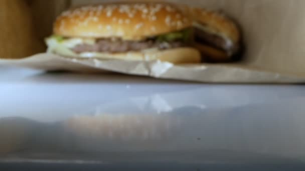 Super-Nahaufnahme. Hamburger mit Sesam in einer Papiertüte — Stockvideo