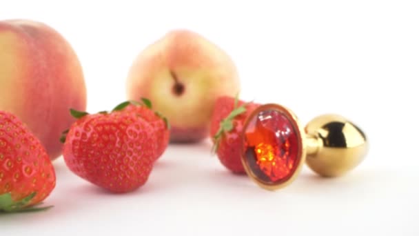 Close-up. peach, strawberry and butt plug isolated on white background — Stockvideo