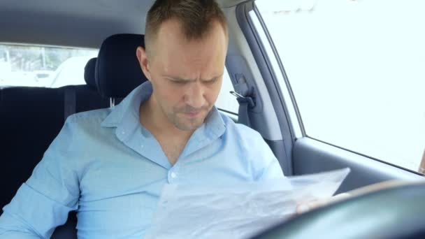 开车的男性司机在车里检查纸质文件。复制空间 — 图库视频影像