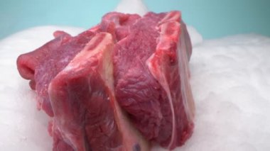 Aşırı yakın plan, detaylı. Kemiğin üzerinde buharlı çiğ et parçası.