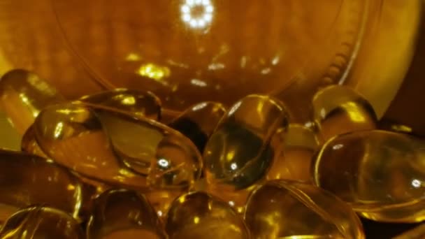 Cápsulas amarelas transparentes com vitamina líquida dentro do frasco — Vídeo de Stock