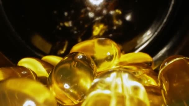 Прозрачные желтые капсулы с жидким витамином внутри банки — стоковое видео