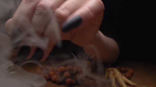 Closeup, detailed. hands of a witch with black nails above a bowl of thick smoke — Stock Video