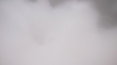 Aşırı yakın plan, detaylı. Siyah zemin üzerinde kuru buzdan kalın beyaz buhar