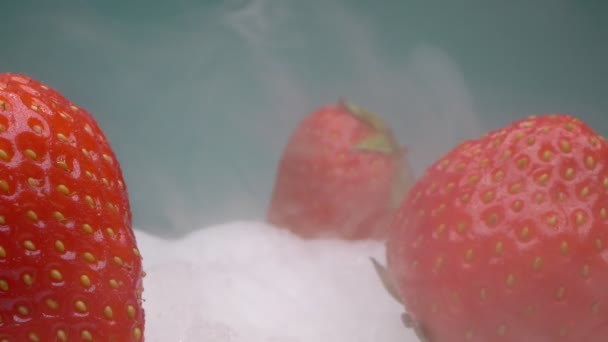 Close-up extremo, detalhado. os morangos vermelhos encontram-se no gelo seco na fumaça — Vídeo de Stock