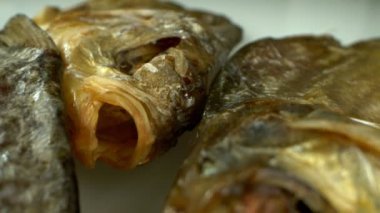 Son derece yakın plan, detaylı. Masada bir sürü kurutulmuş çipura var.