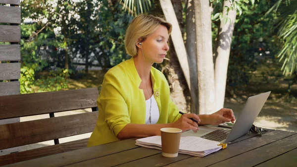 Wanita bisnis yang mengadakan konferensi video melalui laptop di sebuah kafe luar ruangan — Stok Foto