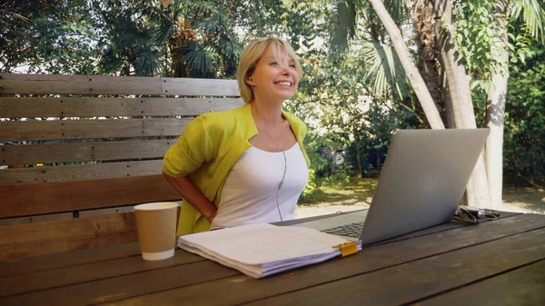 Donna d'affari che tiene videoconferenza via computer portatile in un caffè all'aperto — Foto Stock