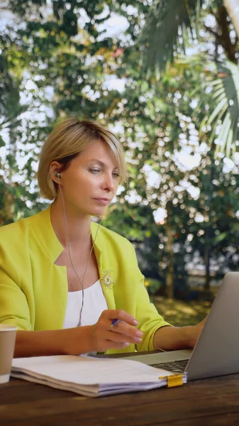 Вертикально. бізнес-леді проводить відеоконференцію через ноутбук у відкритому кафе — стокове фото