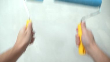 Yakın plan. Birinci şahıs görüşü. Erkek elleri boya silindiri tutuyor.