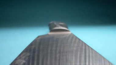 Aşırı yakın plan, detaylı. Mavi arka planda metal bir bıçak.