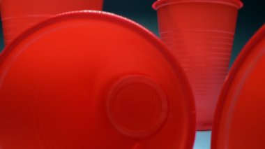 Son derece yakın plan, detaylı. Kokteyl pipetli kırmızı plastik bardaklar. 