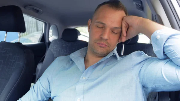 Um retrato de um homem cansado em um carro que adormece ao volante — Fotografia de Stock