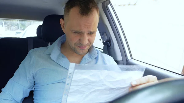 Motorista masculino chateado no carro examina documentos em papel. espaço de cópia — Fotografia de Stock