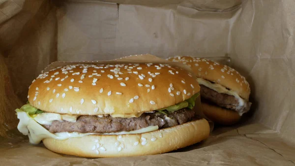 Супер крупный план. гамбургер с кунжутом внутри бумажного пакета — стоковое фото