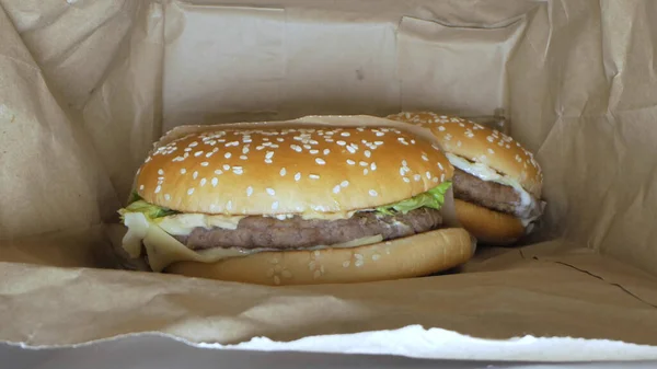 Супер крупный план. гамбургер с кунжутом внутри бумажного пакета — стоковое фото