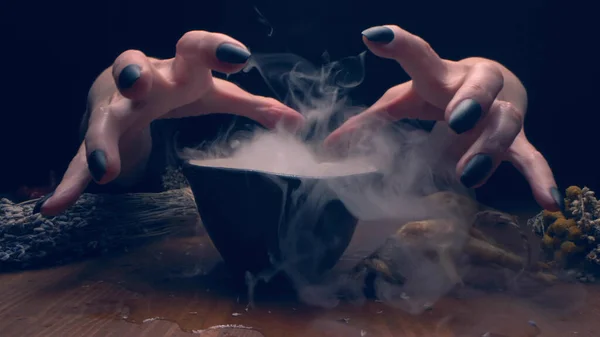 Closeup, detailed. hands of a witch with black nails above a bowl of thick smoke — Stock Photo, Image