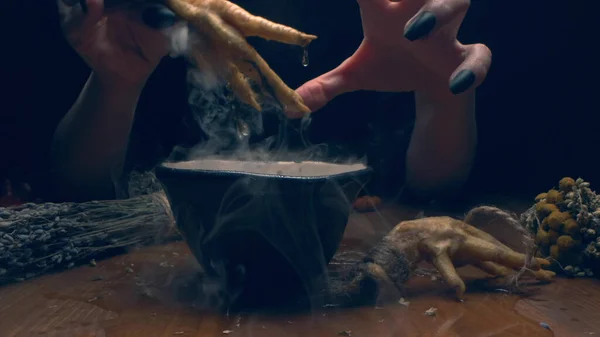 Nahaufnahme, detailliert. Hände einer Hexe mit schwarzen Nägeln über einer Schüssel mit dickem Rauch — Stockfoto