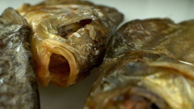 Son derece yakın plan, detaylı. Masada bir sürü kurutulmuş çipura var.