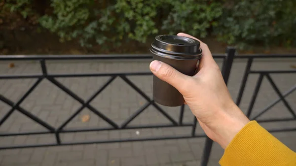 한 남자가 손에 일회용 커피를 들고 길을 걷고 있다 — 스톡 사진