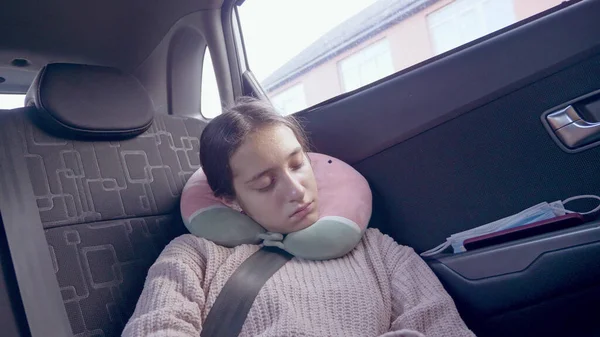 Una adolescente en un suéter duerme en un coche en movimiento en el asiento del pasajero — Foto de Stock