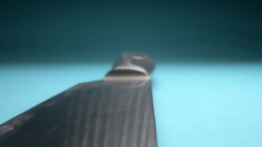 Aşırı yakın plan, detaylı. Mavi arka planda metal bir bıçak.