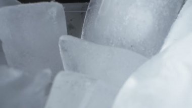 Son derece yakın plan, detaylı. Plastik şeffaf bir kabın içindeki buz küpleri