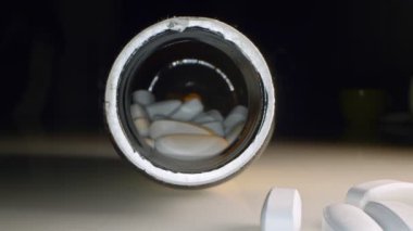 Aşırı yakın plan, detaylı. Sarı kavanozdaki beyaz haplar.