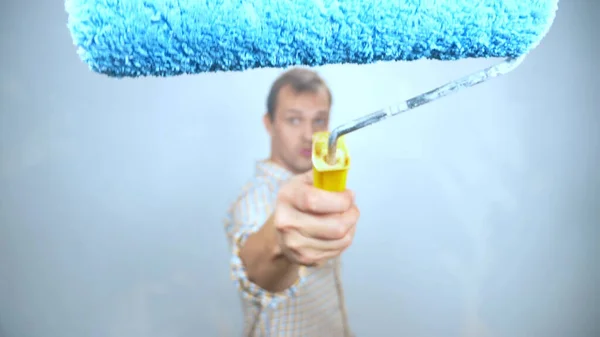 Cheerful man with rollers for painting walls paints over the camera. copy space — Stock Photo, Image